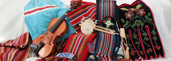 Still life of items tied to Metis culture: sashes, ribbon skirt, fiddle, traditional beadwork.