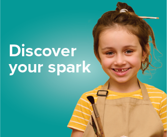 A smiling child holding a paint palette, text reads Discover your spark.